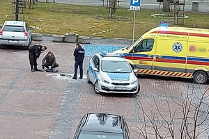 Miejsce zdarzenia. Stojący na placu policjanci obok radiowozu i karetki