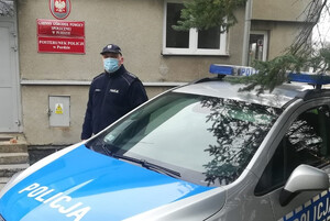 asp. szt. Jacek Witkowski stojący przy radiowozie przy Posterunku Policji w Purdzie
