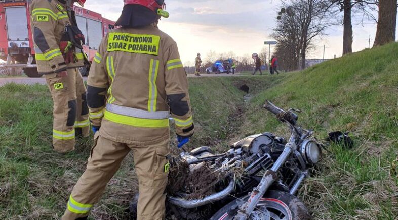 motocykl w rowie przy nim 2 strażaków