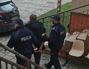 Zatrzymany mężczyzna prowadzony przez policjantów