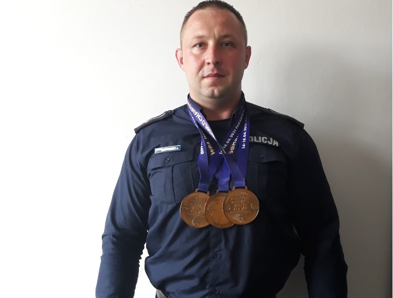 mł. asp. Cezary Urbaniak w mundurze z zawieszonymi na szyi medalami