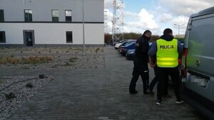 dwóch policjantów po samochodzie