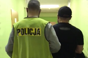 Zatrzymany mężczyzna prowadzony przez policjanta