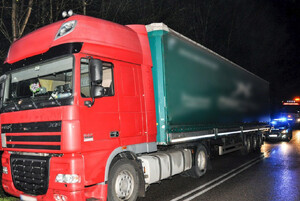 Ciężarówka z podłączoną kradzioną naczepą na drodze, a za nią radiowóz