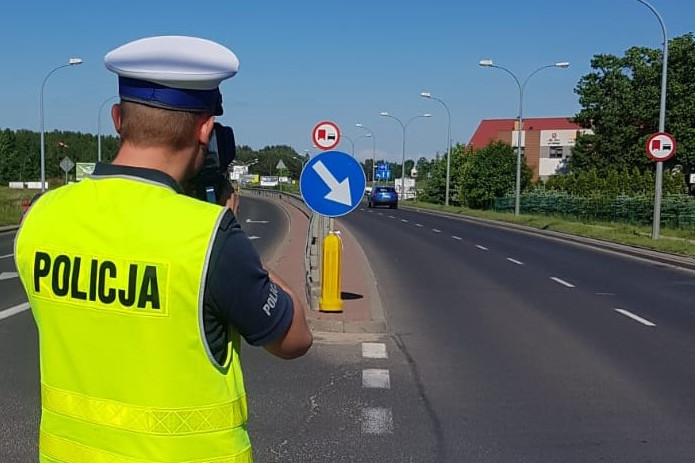 Policjant podczas pomiaru prędkości stojący na drodze