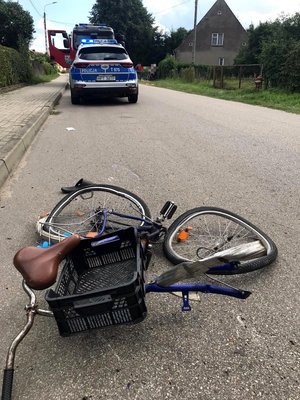 Uszkodzony rower oraz radiowóz w tle
