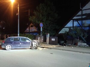pojazd uderzył w ogrodzenie do posesji.. Zdjęcie zrobione w porze nocnej