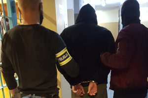 Zatrzymany mężczyzna prowadzony przez policjantów