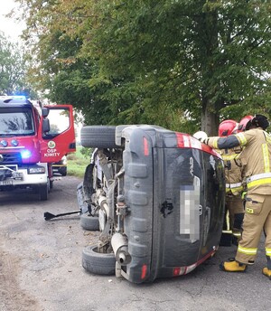 Pojazd uszkodzony leżący na boku na drodze wokół służby ratunkowe