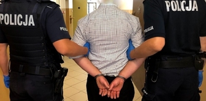 Zatrzymany mężczyzna prowadzony przez policjantów z KPP w Piszu