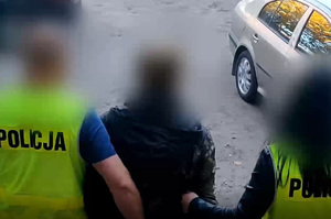 Zatrzymany mężczyzna prowadzony przez policjantów