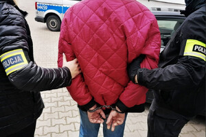 Zatrzymany mężczyzna prowadzony przez policjantów
