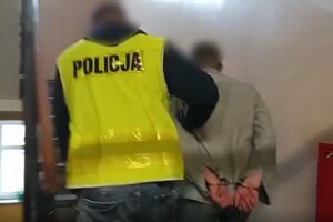 Zatrzymany mężczyzna prowadzony przez policjanta