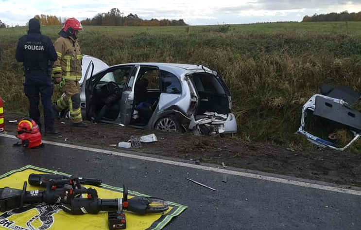 Po prawej stronie drogi w rowie uszkodzony pojazd, przy nim policjant oraz strażak