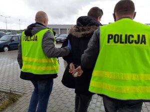 Zatrzymany mężczyzna prowadzony przez policjantów