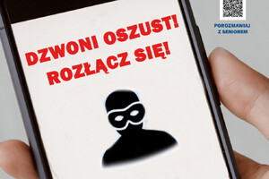 Na zdjęciu widoczna jest dłoń trzymająca telefon, na którym wyświetlany jest napis &amp;quot;Dzwoni oszust! Rozłącz się!&amp;quot; oraz sylwetka zamaskowanego przestępcy.