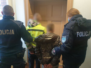Policjanci prowadzą 2 osoby zatrzymane