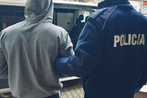 Zatrzymany mężczyzna prowadzony przez policjanta