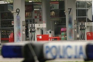 Dach radiowozu a w tle stacja paliw