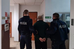 Zatrzymany mężczyzna prowadzony przez policjantów
