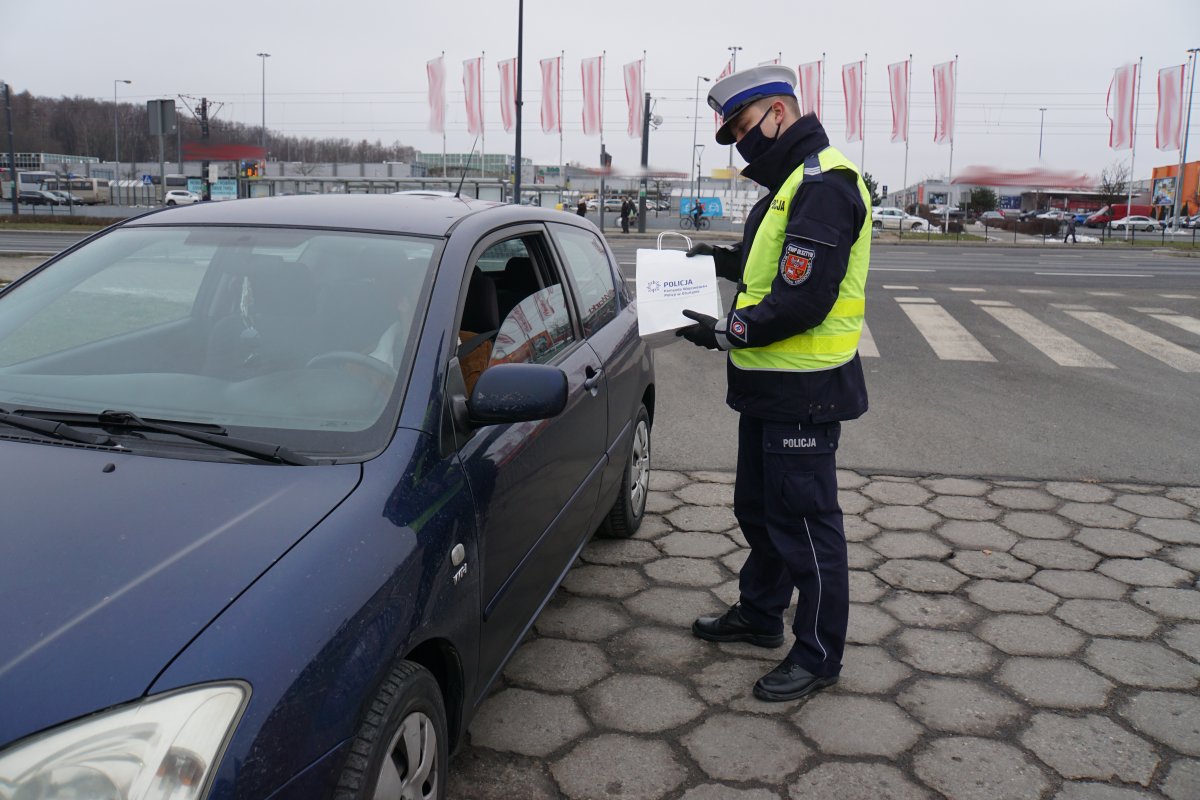 Policjant przekazuje upominek dla kierowcy