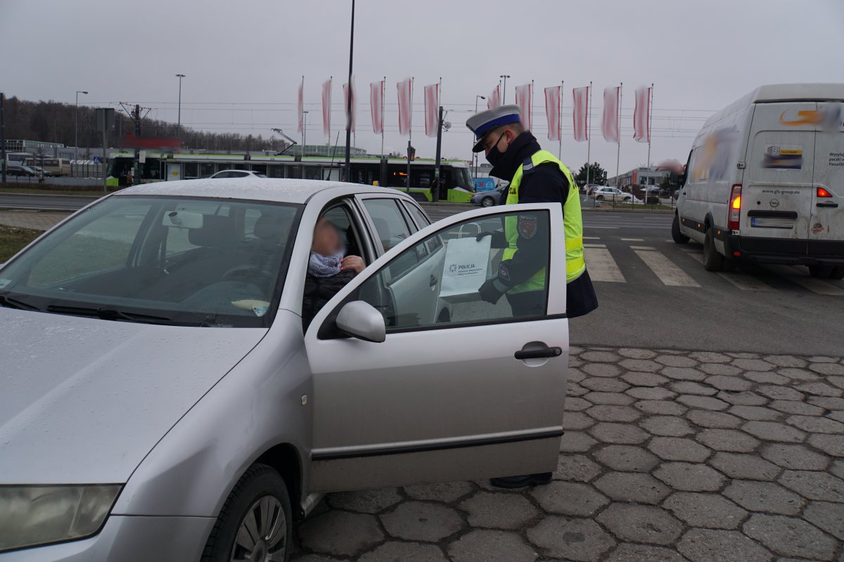 policjant przekazuje upominek dla kierowcy