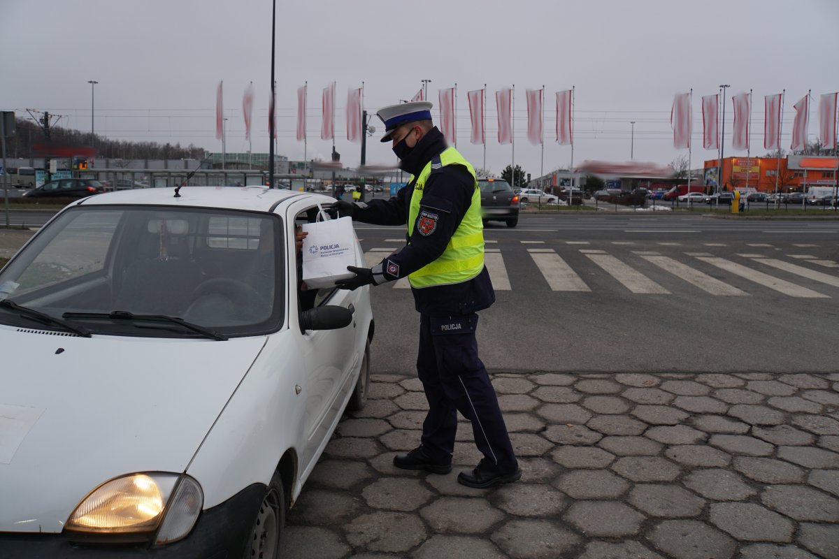 Policjant przekazuje upominek dla kierowcy