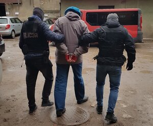 Zatrzymany mężczyzna prowadzony przez policjantów
