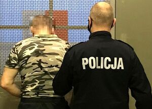 policjant prowadzi osobę zatrzymaną
