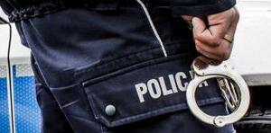 policjant trzyma w ręku kajdanki