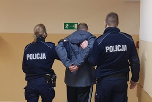Zatrzymany mężczyzna prowadzony przez policjantów