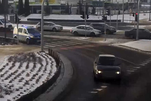 Zrzut ekranu z monitoringu miejskiego z fragmentu pościgu. Auto na skrzyżowaniu i jadący za nim radiowóz