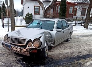 uszkodzony przód pojazdu w tle budynek