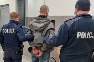 Zatrzymany mężczyzna prowadzony przez policjantów