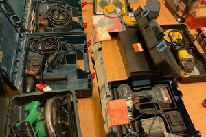 Odzyskane elektronarzędzia, leżące na podłodze i poukładane w walizkach