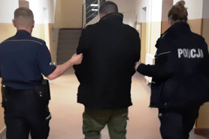 Zatrzymany mężczyzna prowadzony przez policjantów