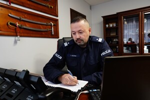 nadinsp. Tomasz Klimek siedzący za biurkiem