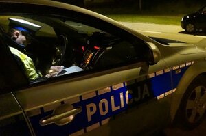 policjant w radiowozie wypisuje mandat