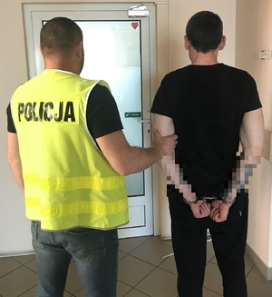 Policjant prowadzi zatrzymanego