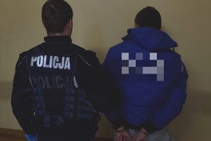 Zatrzymany mężczyzna prowadzony przez policjanta