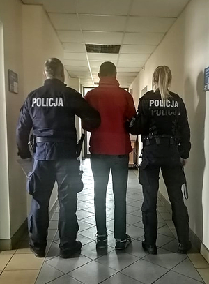 Policjanci prowadzą zatrzymanego