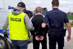 Zatrzymany mężczyzna prowadzony przez policjantów do radiowozu