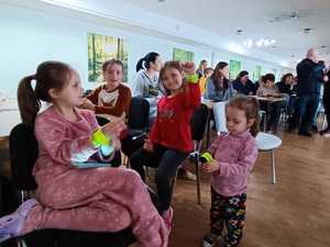 Dzieci uczestniczące w spotkaniu z policjantami nakładające sobie odblaski na ręce