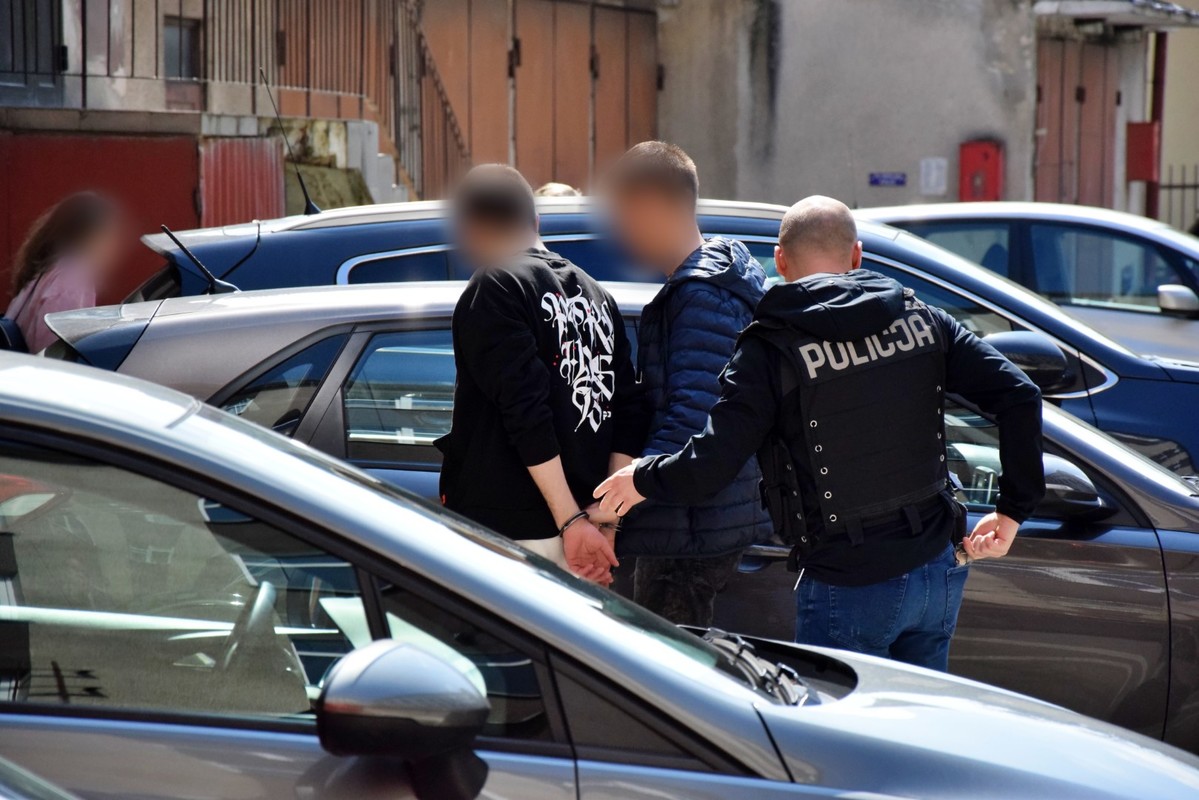 Zatrzymani mężczyźni prowadzeni przez policjantów