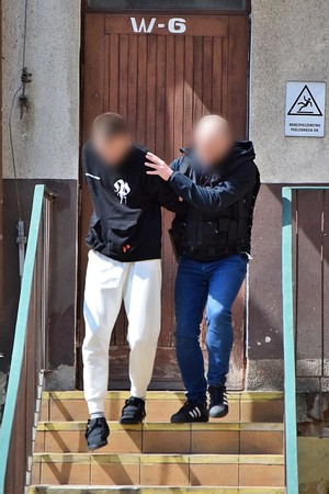 Zatrzymani mężczyźni prowadzeni przez policjantów