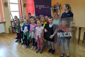 Policjantka podczas spotkania z dziećmi pozują do zdjęcia grupowego