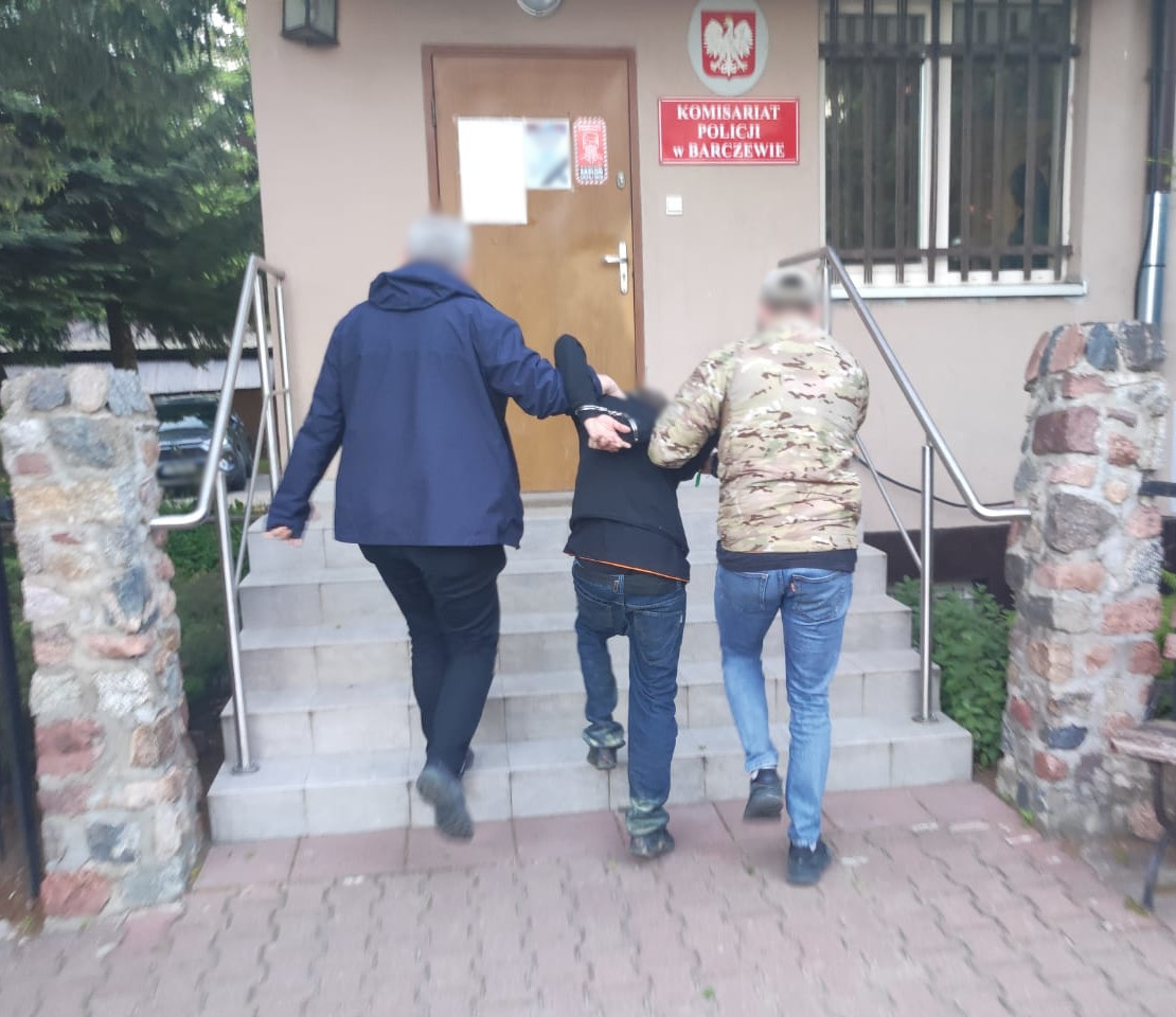 zatrzymany mężczyzna prowadzony przez policjantów operacyjnych