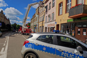 Radiowóz i wóz strażacki na ulicy w Barczewie podczas akcji neutralizacji roju pszczół