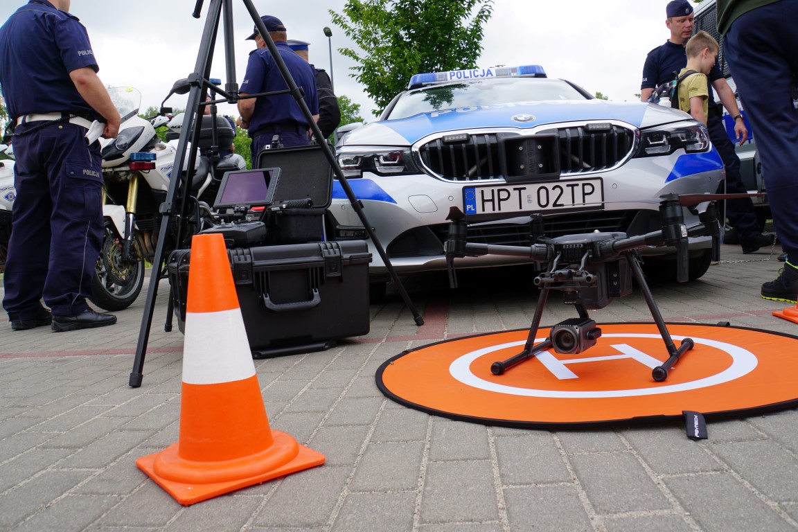 Policyjny dron ustawiony na parkingu przed radiowozem