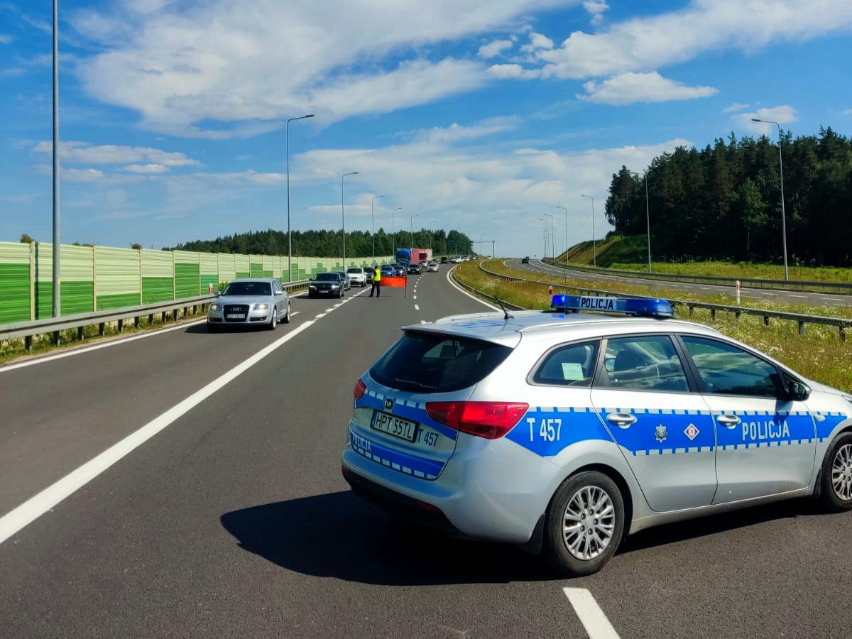 Policjant kierujący na wyznaczony objazd na drodze ekspresowej S7